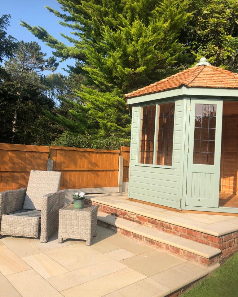 Sage summerhouse with sandstone steps and patio seating area