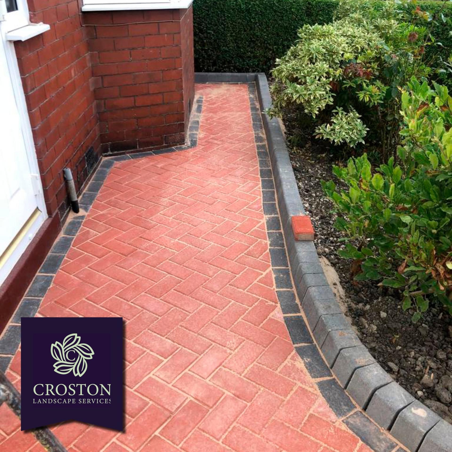 Red block paving path with charcoal kerb edging