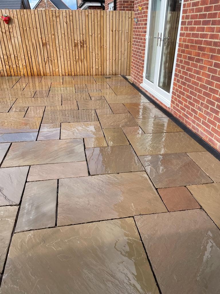 Sandstone patio sweeping up to patio doors of a new build home