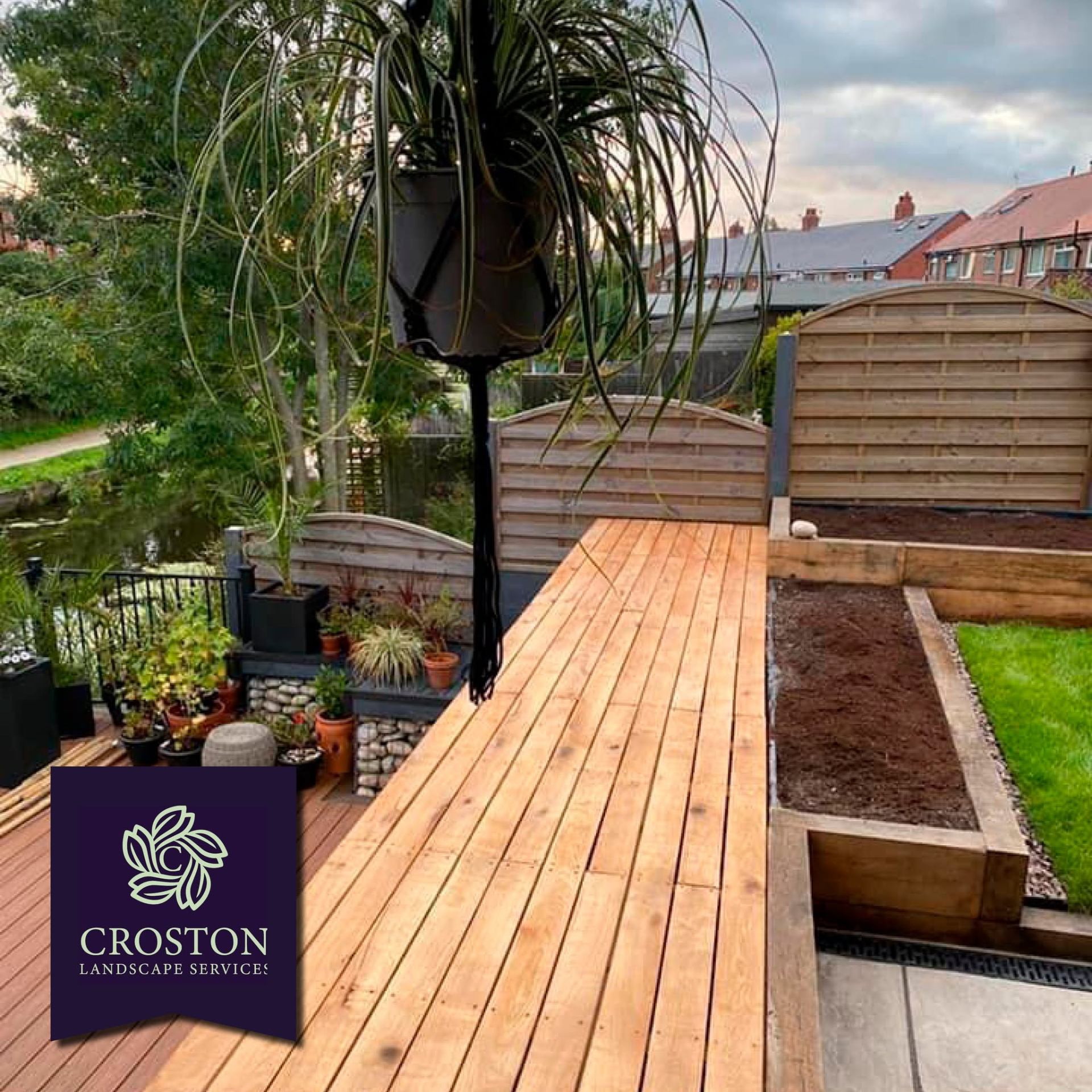 Cedar deck with canal view, sleeper planters and hanging foliage